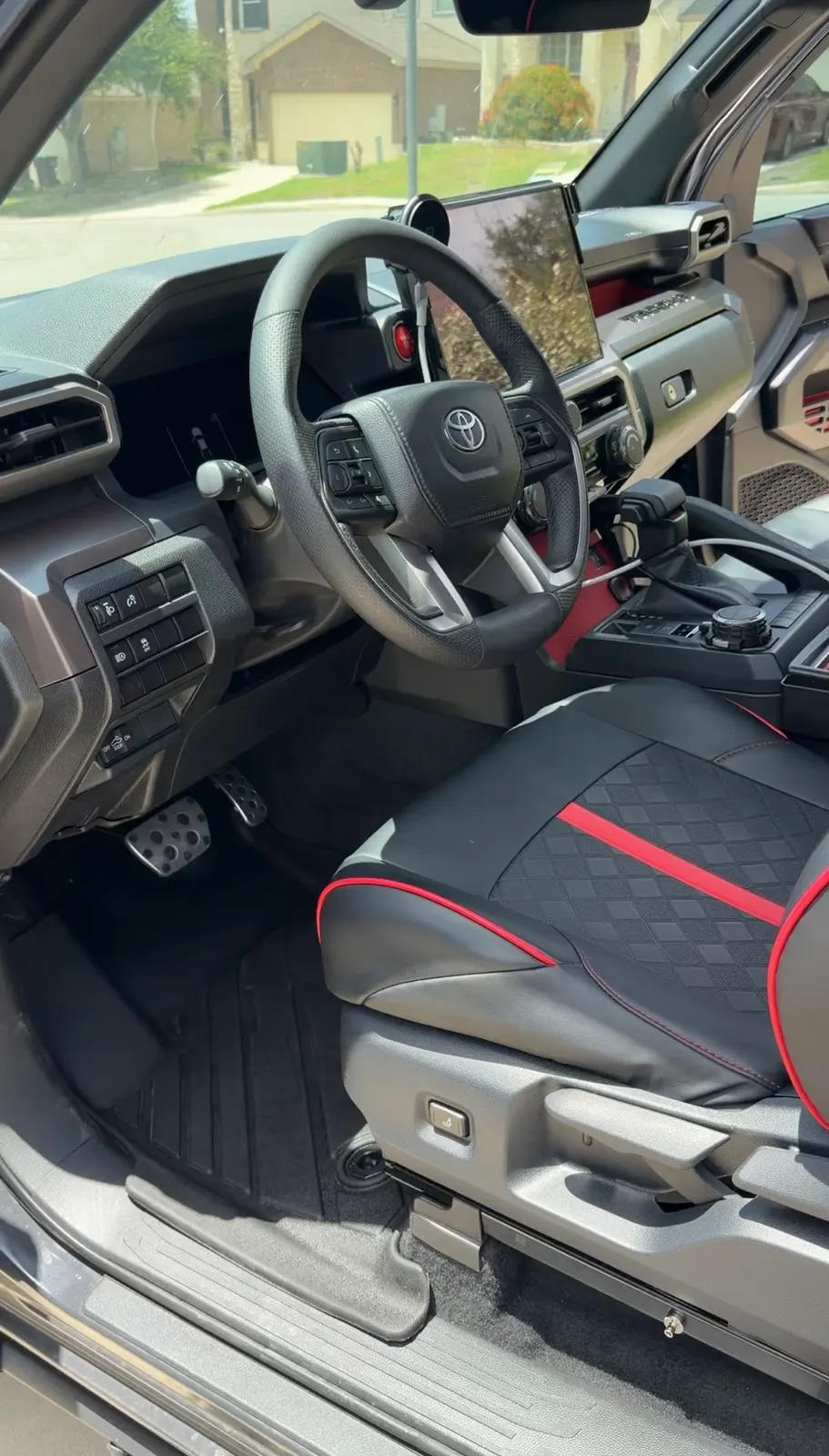 The Tacoma's driver area after an interior detail: mats cleared, dash, wheel and seat wiped down.